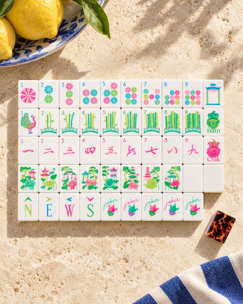 The Bougainvillea Set laid out in rows on a sunny stone table, with magenta and green faces