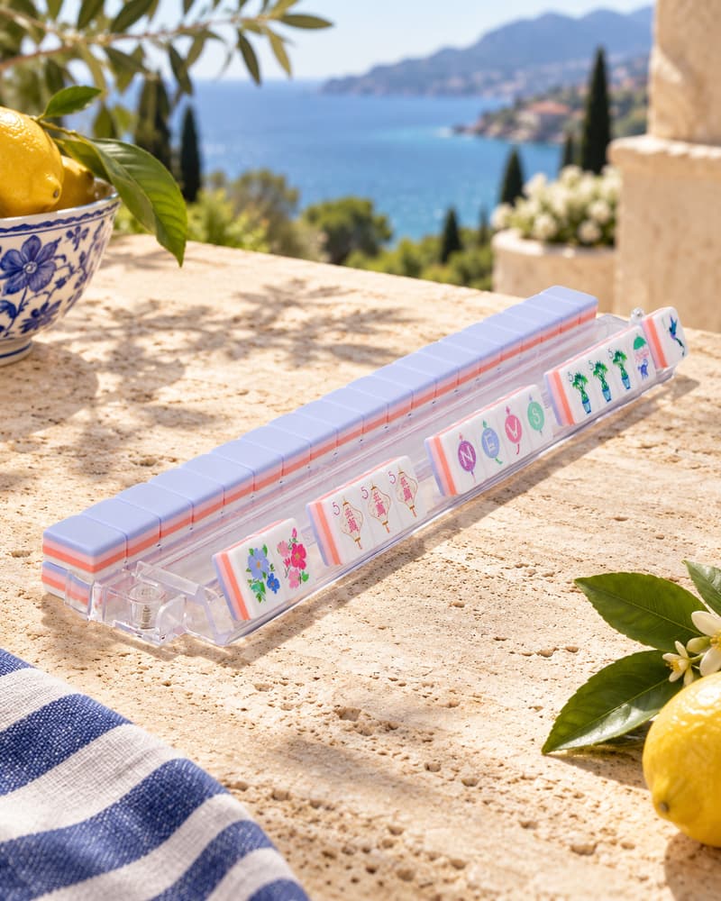 Sorbetto Set tiles with periwinkle backs standing in an acrylic rack by the sea